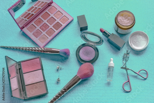 Brush and cosmetic isolated on a green pastel background. Top view.