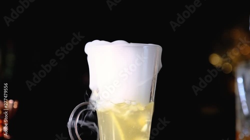 Bhot cocktail with dry ice close up, Barman holding ice cube cocktail glass. Bartender preparing alcoholic cocktails. close up. photo