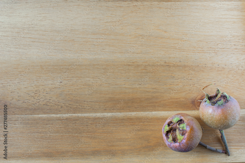 fresh medlar fruits on a wooden board with copy space fresh medlar fruits on a wooden board with copy space