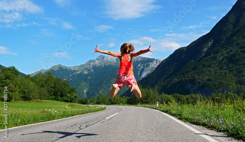 femme qui saute sur une route avec montagne, paysage Slovénie