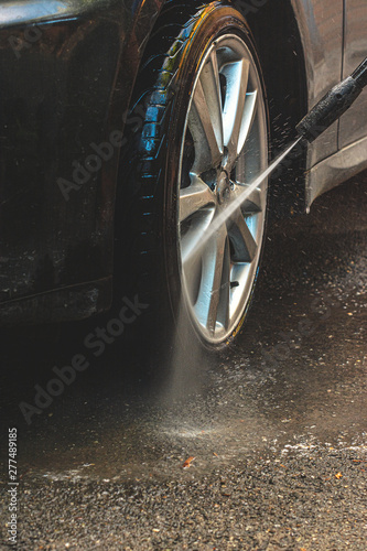 Wallpaper Mural washing the wheels of the car with a hose Torontodigital.ca