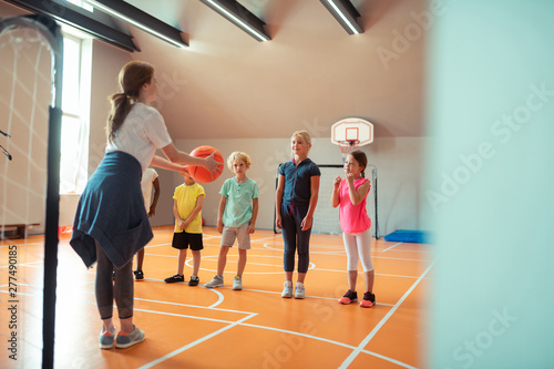 Coach teaching her pupils how to play ball.