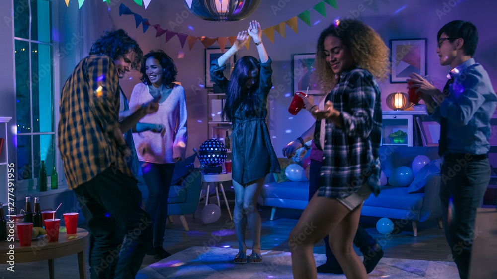 At the College House Party: Diverse Group of Friends Have Fun, Dancing and Socializing. Boys and Girls Dance in the Circle. Disco Neon Strobe Lights Illuminating Room. 