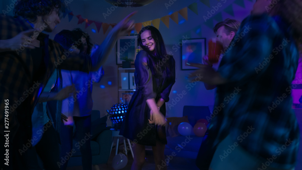 At the College House Party: Young Girl Dances in the Middle of a Circle of People. Diverse Group of Friends Have Fun, Dancing and Socializing. Disco Neon Strobe Lights Illuminating Room. 