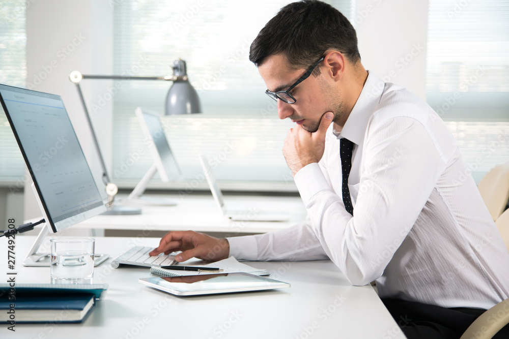 Serious businessman working with computer Serious businessman working with computer