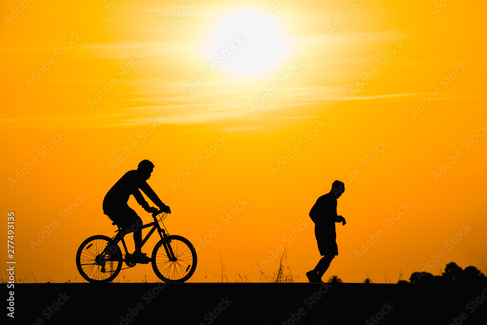 Silhouette man cycling on sunset background