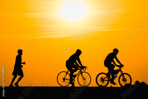 Silhouette man cycling on sunset background