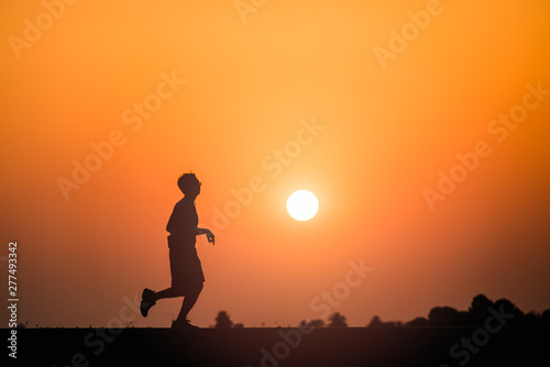 Fototapeta Naklejka Na Ścianę i Meble -  Silhouette man running on sunset background