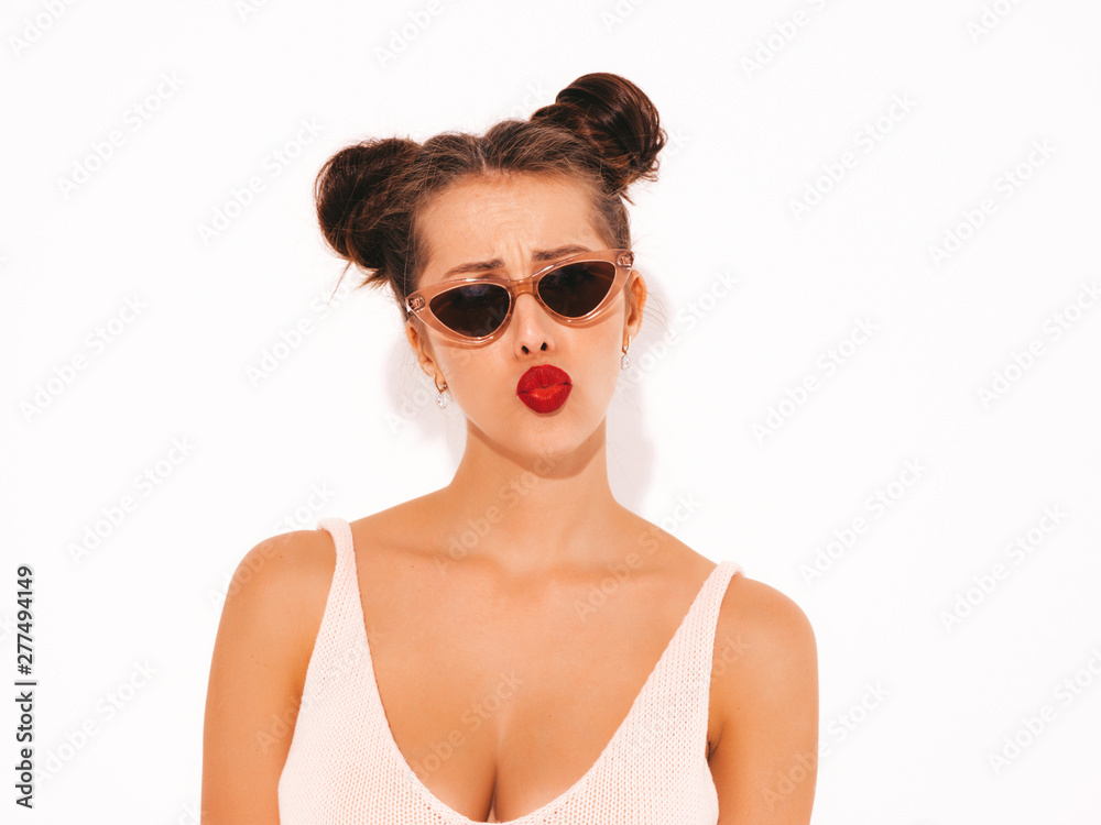 Closeup portrait.Young beautiful sexy hipster woman with red lips in sunglasses.Trendy girl in summer swimwear bathing suit. Positive female makes duck face.Funny model isolated on white.Two horns Closeup portrait.Young beautiful sexy hipster woman with red lips in sunglasses.Trendy girl in summer swimwear bathing suit. Positive female makes duck face.Funny model isolated on white.Two horns