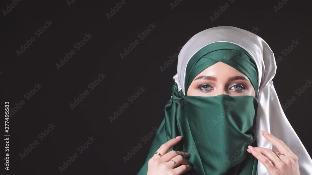 Young Islamic woman in national costume posing on camera in the Studio Young Islamic woman in national costume posing on camera in the Studio