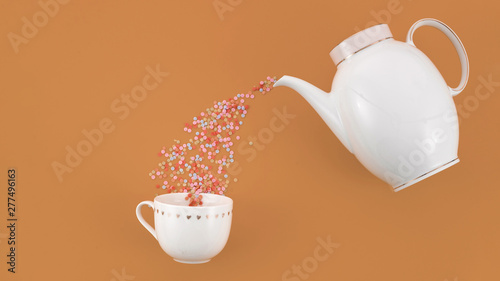 Colorful confetti flowing from teapot in the white cup against brown backdrop