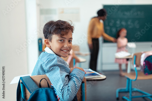 Handsome schoolboy smiling while enjoying the day photo