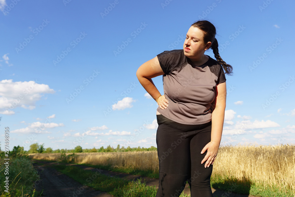 Overweight woman has short breath at outdoor jogging workout. Fitness, sports and health care Overweight woman has short breath at outdoor jogging workout. Fitness, sports and health care