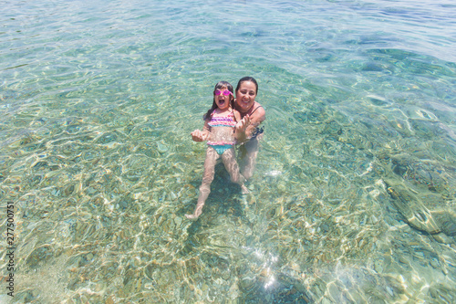 Mother and daughter having fun together in the sea during vacation