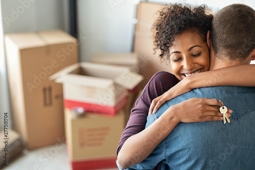 Woman hugging man and holding home keys photo