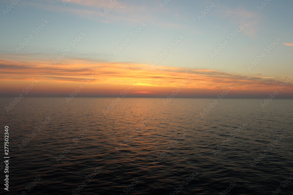 evocative image of sunrise over the sea with the sun rising over the horizon