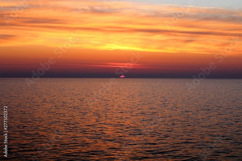 evocative image of sunrise over the sea with the sun rising over the horizon