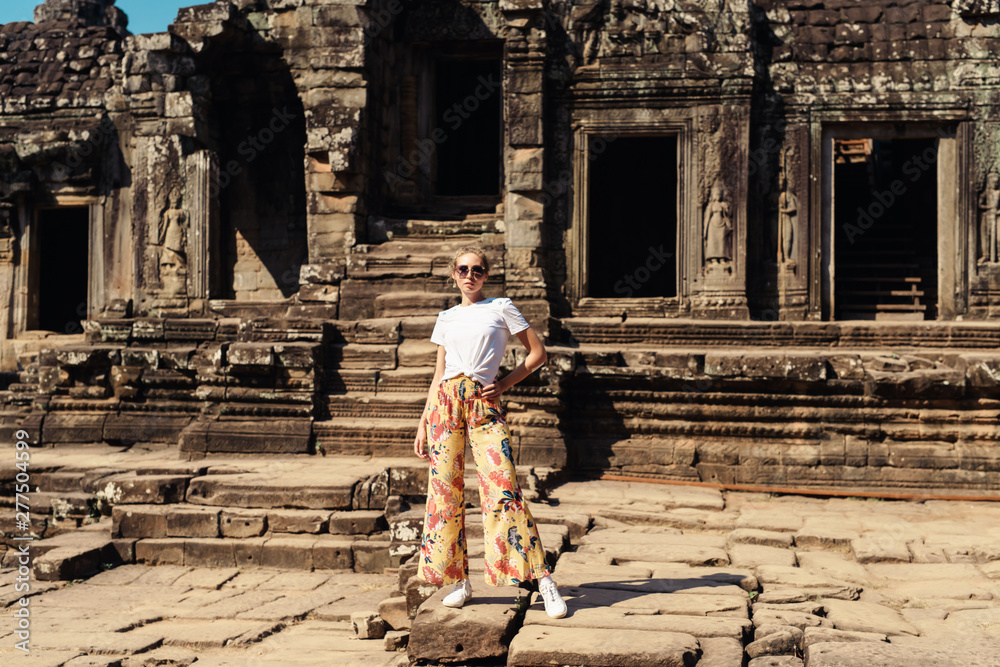Young female tourist traveler is posing at Angkor Wat temple, Siem Reap, Cambodia