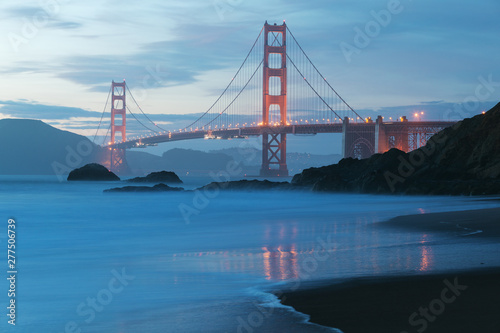 Classic panoramic view of famous Golden Gate Bridge seen from scenic Baker Beach in beautiful golden evening light on adusk with blue sky and clouds in summer  San Francisco  California  USA
