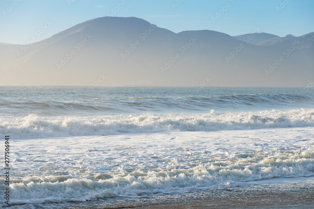 Amazing sunny day with endless horizon and incredible foamy waves. Beautiful beach, California, USA seascape and sun on blue sky background