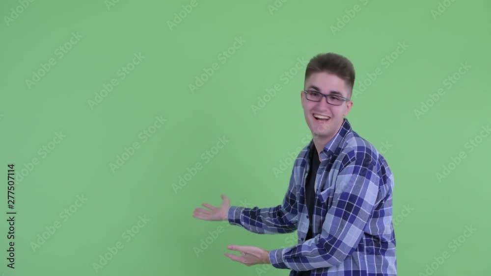 Happy young hipster man showing to back and looking surprised Happy young hipster man showing to back and looking surprised