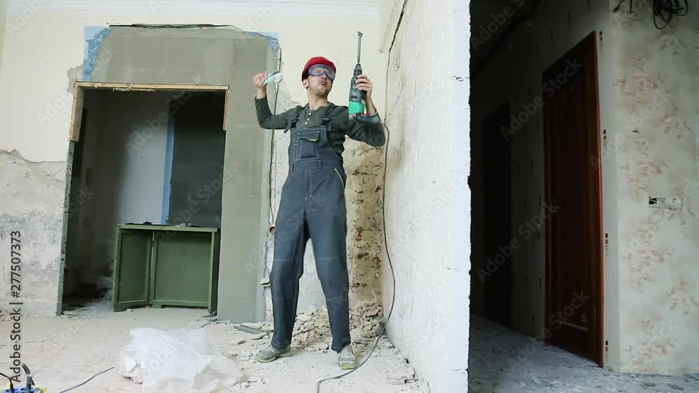 Erotic dance of the Builder with a puncher in hands and money Erotic dance of the Builder with a puncher in hands and money