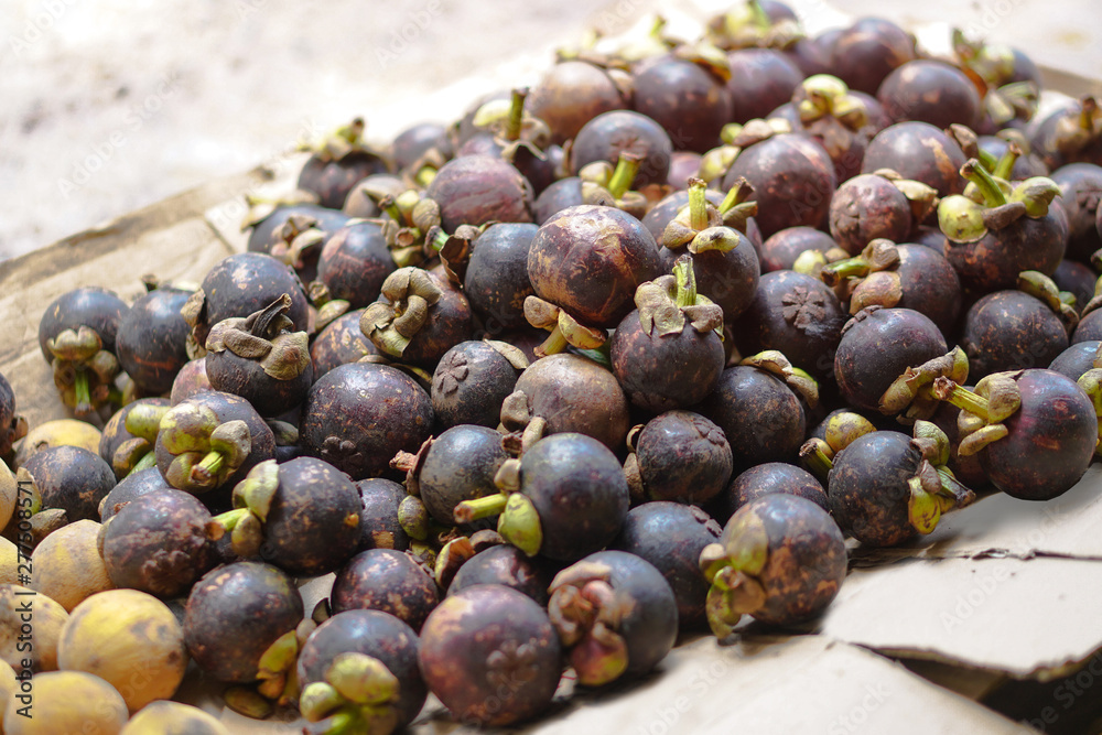Fototapeta premium Beautiful harvest of mangosteen on the market in Asia. Vegetarian theme. Stock photo