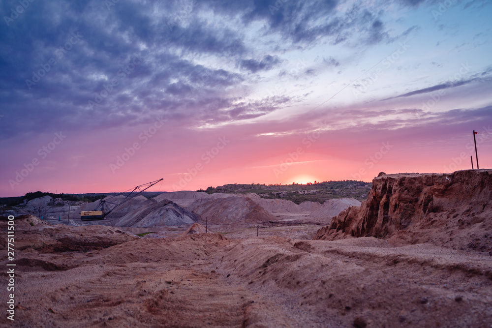 Coal mining at an open pit at sunset