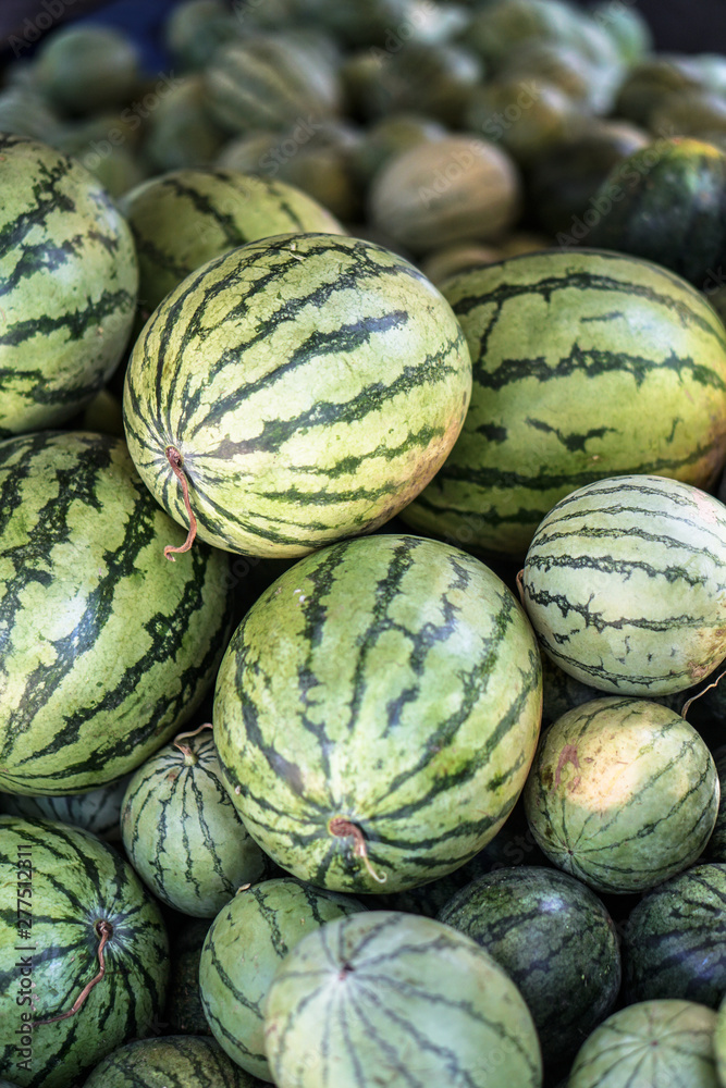Watermelons and melons are sold on the market in Asia. Sale of vegetarian fruits outdoors. Stock photos Watermelons and melons are sold on the market in Asia. Sale of vegetarian fruits outdoors. Stock photos