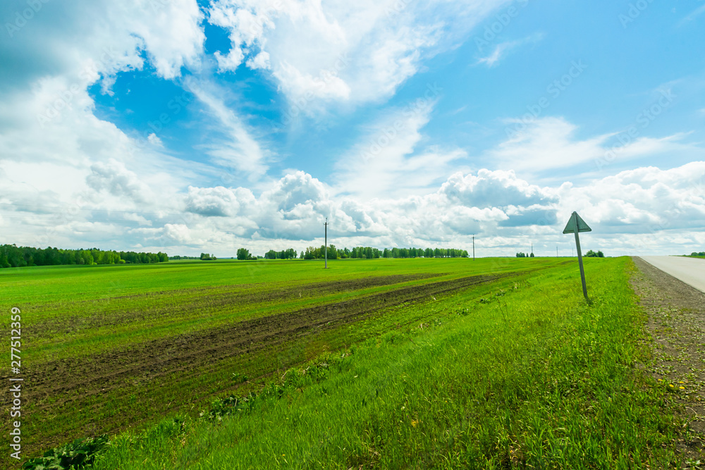 Landscape rural road and blue sky. Straight gravel road leading to the horizon. Landscape rural road and blue sky. Straight gravel road leading to the horizon.