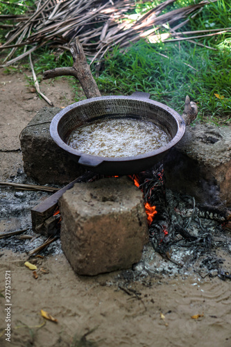 Coconut oil is covered in a large pot on the fire. Exotic countries of Asia and home life. Stock photo