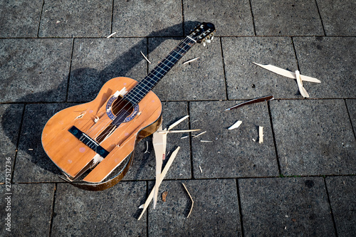 Slika na platnu A smashed guitar lies on the pavement.