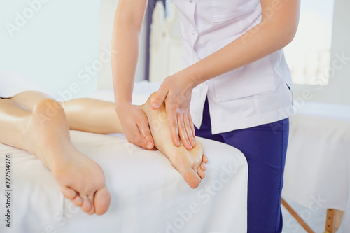 Therapist massaging foot of client lying