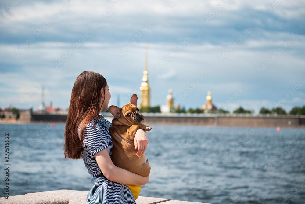 young woman shows french bulldog puppy promenade