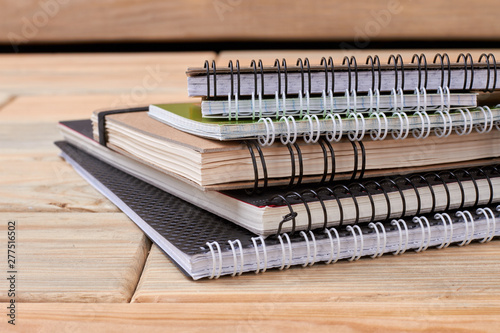 Obraz na plátně Stack of spiral notebooks on wooden background