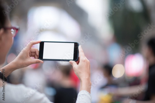 Woman with smartphone take pictures in modern city