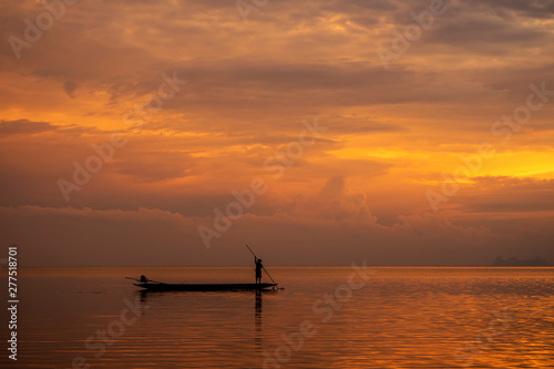 Minimal silhouette fisherman on the lake with twilight sky.