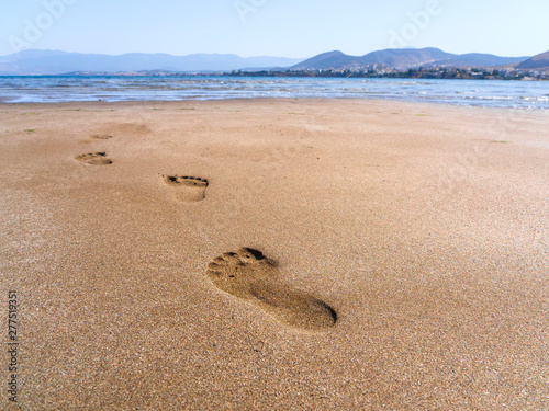 Panoramic views of the sandy beach, the mountains and footprints in the sand at low tide on Liani Ammos beach in Halkida, Greece on a Sunny summer  day the island of Evia photo