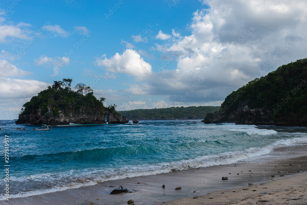 View of tropical beach, sea rocks and turquoise ocean, blue sky. Crystal Bay, Nusa Penida, Indonesia. View of tropical beach, sea rocks and turquoise ocean, blue sky. Crystal Bay, Nusa Penida, Indonesia.