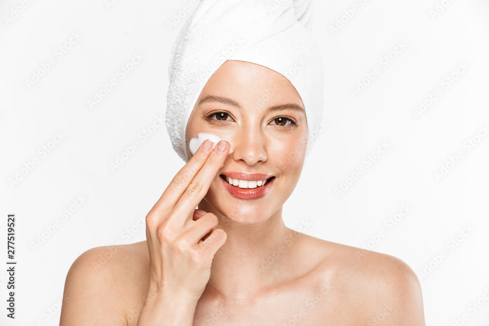 Image of caucasian half-naked woman wrapped in towel washing her face with foaming cleanser Image of caucasian half-naked woman wrapped in towel washing her face with foaming cleanser