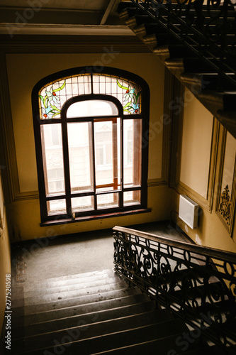 Inside a residential building with a staircase and a window.