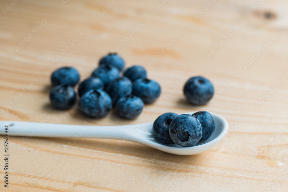 Many fresh bluederry on the wooden table close up Many fresh bluederry on the wooden table close up