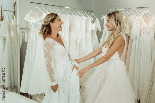 Two beautiful brides laughing in a wedding salon.