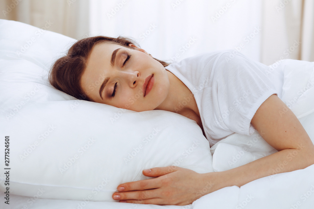 Beautiful young woman sleeping while lying in her bed. Concept of pleasant and rest reinstatement for active life Beautiful young woman sleeping while lying in her bed. Concept of pleasant and rest reinstatement for active life