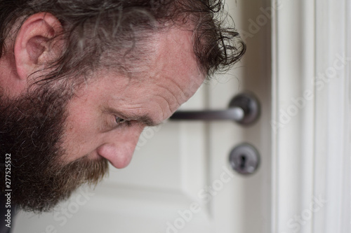 Portrait of a bearded man of the European type who overhears at the door. photo