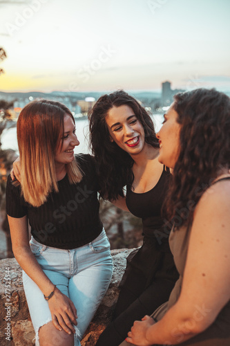 Three beautiful girls having good time near to the beach at sunset