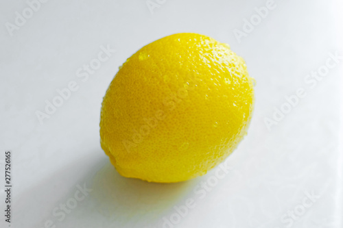 One fresh lemon on white kitchen table