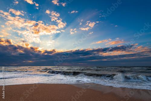 Beach with waves at colorful sunset © Vastram