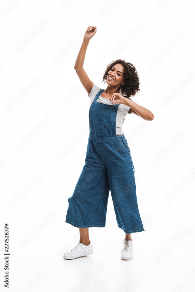 Image of joyful african american woman dressed in denim overalls smiling and dancing Image of joyful african american woman dressed in denim overalls smiling and dancing