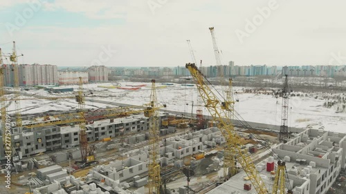 calm construction site of dwelling complex with tower cranes on nice winter weekend bird eye view photo